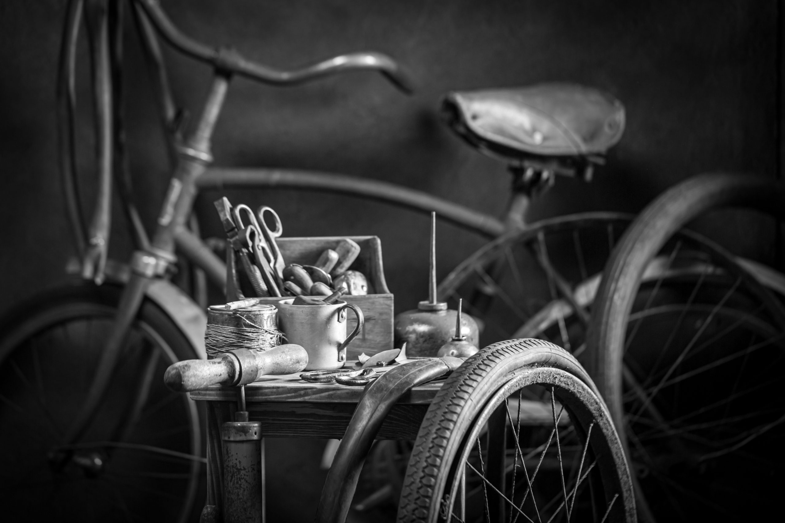 vous pouvez voir un vélo vintage en fond, et une petite table devant avec une caisse à outil posée dessus.